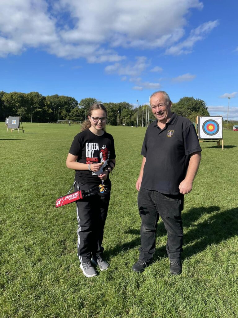 a member being presented with a three gold end badge