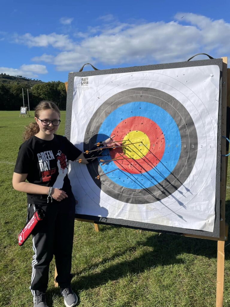 a member of neath archers' pointing at arrows in the gold